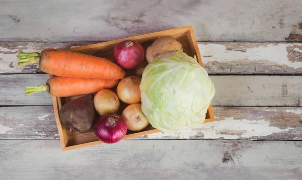 Surtido de verduras frescas en bandeja de madera sobre fondo de madera envejecida . —  Fotos de Stock