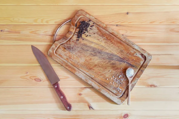 Schneidebrett, Messer und Würze auf Holzgrund. — Stockfoto