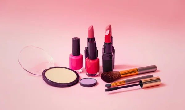 Set di cosmetici per il trucco, smalti e pennelli su sfondo rosa. Focus selettivo . — Foto Stock