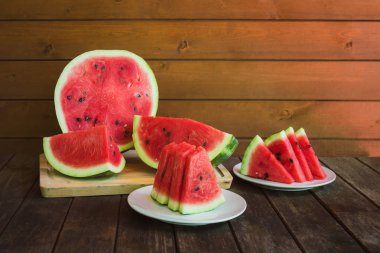 Karpuz dilimleri ve kırsal ahşap masada yarım karpuz. Seçici odak.
