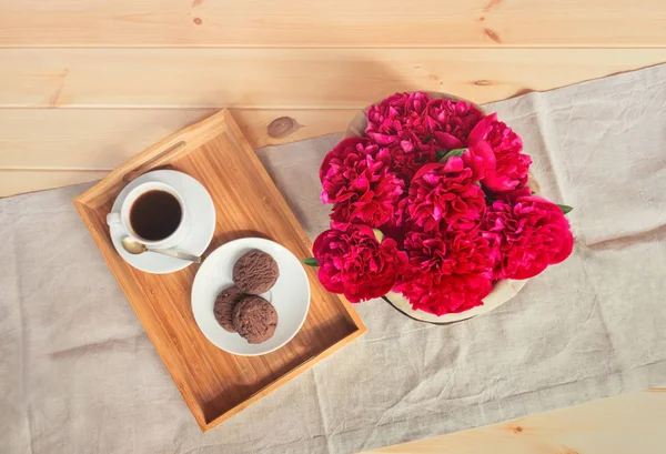 Hermosas flores de peonía roja, taza de café y galletas de chocolate . —  Fotos de Stock