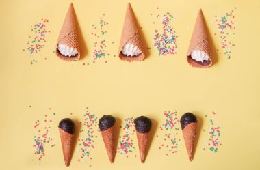 Vanilyalı dondurma külahları ve sarı arka planda şeker serpintisi yıldızları. 