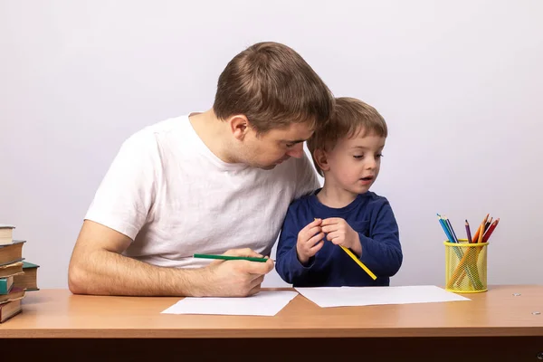 Menino Com Pai Senta Uma Mesa Com Livros Aprendendo Escrever — Fotografia de Stock