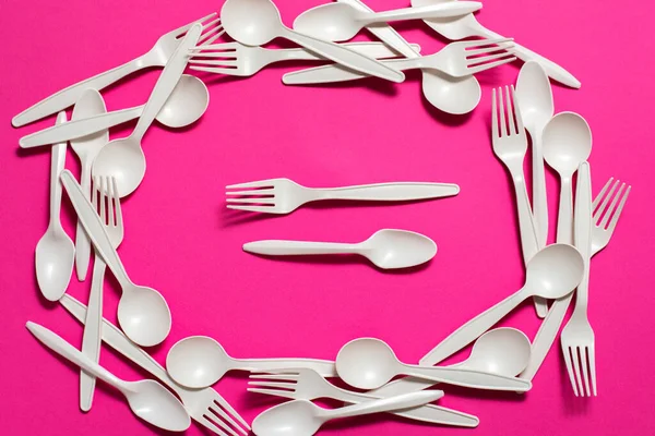 biodegradable eco-friendly disposable tableware on a pink background. forks, spoons,  cornstarch . isolate. modern replacement for plastic. biomaterials.