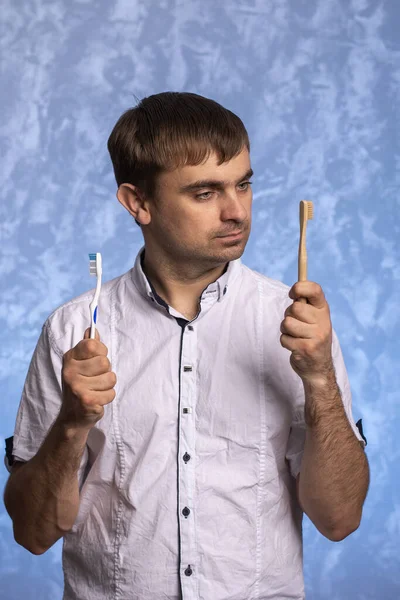 Hombre Con Una Camisa Blanca Sostiene Bambú Cepillos Dientes Plástico — Foto de Stock