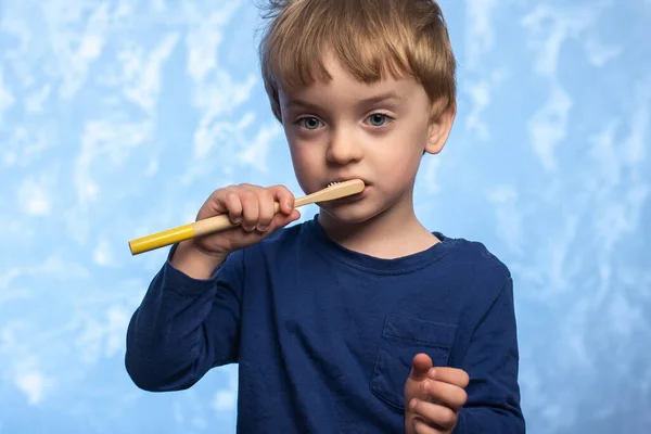 Küçük Çocuk Dişlerini Mavi Dokuya Sahip Bambu Bir Diş Fırçasıyla — Stok fotoğraf