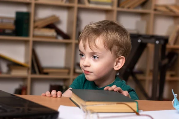 Niño Pequeño Mira Ordenador Portátil Mientras Está Sentado Una Mesa —  Fotos de Stock