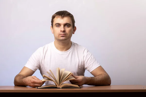 Serieuze Jongeman Zit Aan Een Tafel Met Een Open Boek — Stockfoto