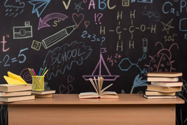 Desk Books Pencils Background Slate Wall Drawings Blackboard Formulas Classroom — Stock Photo, Image