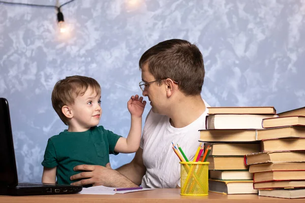 Rapazinho Senta Com Pai Perto Portátil Numa Mesa Com Livros — Fotografia de Stock