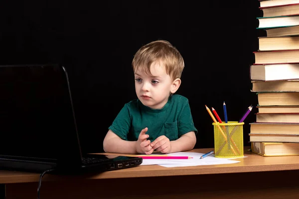 Niño Pequeño Sienta Una Mesa Con Libros Una Computadora Portátil —  Fotos de Stock