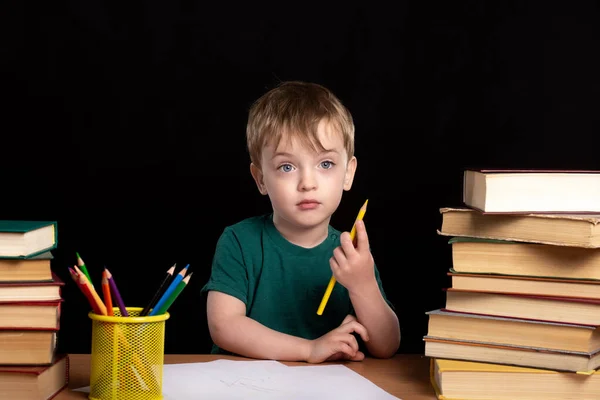 Little Boy Sits Table Books Black Wall Boy Draws Holds Stock Picture