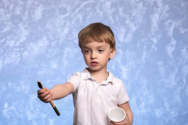 Avrupa görünümlü üç yaşındaki küçük bir çocuk elinde bambu çevre dostu bir diş fırçası ve mısır nişastasından yapılmış tek kullanımlık bir bardak tutuyor. Günlük ağız temizliği.