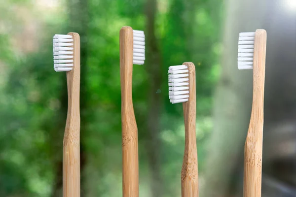 Nærbilde Fire Bambustannbørster Grønn Bakgrunn Miljøvennlige Biologisk Nedbrytbare Hygieneartikler Sted – stockfoto