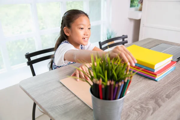 Primary school girl reading and writing book — Stock Photo, Image