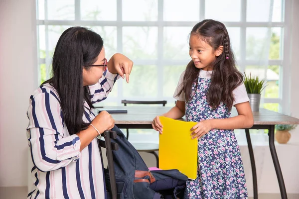 Moeder helpt basisschool meisje verpakking boeken naar de tassen — Stockfoto