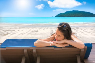 Asyalı seksi kız beyaz kum plaj ve beautifu yatakta güneşlenmek