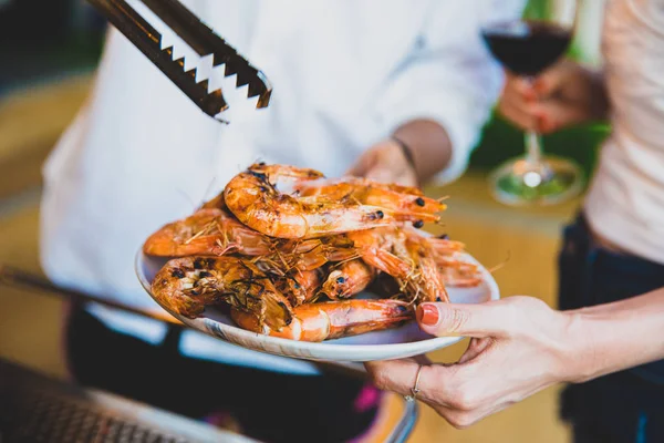 Zblízka grilovaný Krevetový talíř, který drží turistická žena. Skupina t — Stock fotografie