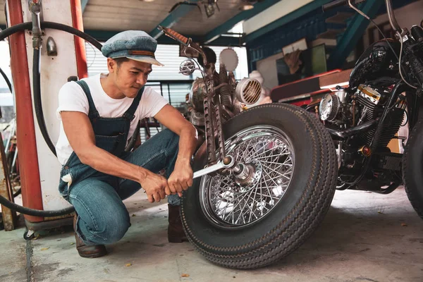 Mechanical technician man maintenance and repair motorbike at workshop