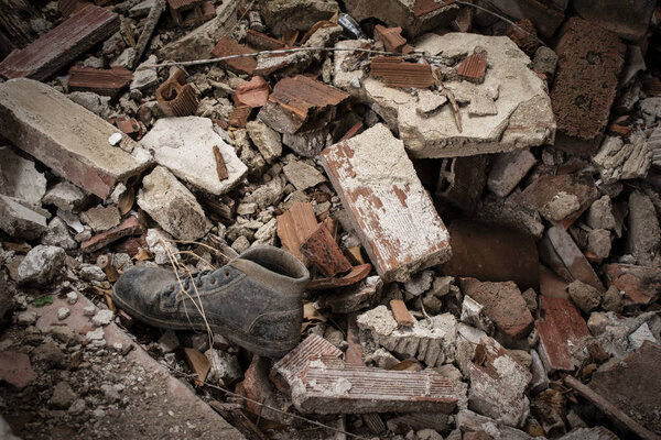 Abandoned boot on a pile of brick rubble