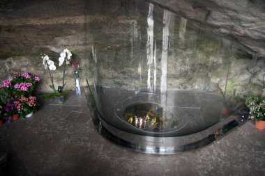 28 Nisan. 2014 Lourdes France The Massabielle Cave (Massabielle Mağarası), Meryem Ana 'nın Bernadette Soubirous adlı bir kıza göründüğü yer. Cam hacıların arkasında mağarayı görebiliyorlar, kutsal kaynağı..
