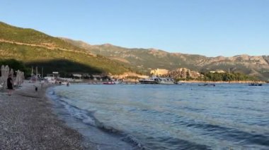 Kıyıdan Adriyatik Denizi'ne Budva, Karadağ kentinde video. Adriyatik Denizi manzarası, plaj Budva manzarası, eski şehir manzarası, dağ manzarası.