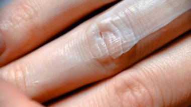 Bir kızın eline kremsi bir kozmetik ürün sürerken çekilmiş yakın çekim videosu. Kozmetik kremler ve losyonlar, spa tedavileri ve vücut bakımı.