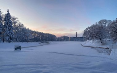 Sakin bir kış manzarası alacakaranlıkta ya da şafakta karla kaplı bir parkı yakalar. Donmuş bir gölet, küçük bir köprü ve uzak bir orman alanıyla olay yerine hakim. Gökyüzü yumuşaklığın gradyanı.