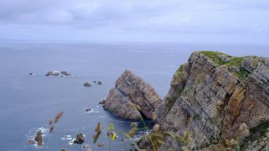 Nefes kesici geniş açılı bir video İspanya 'nın dramatik ve engebeli kıyı şeridini yakalıyor. Görüntülerde daha küçük deniz yığınlarıyla birlikte derin mavi okyanusa keskin bir şekilde düşen görkemli ve kayalık kayalıklar görülüyor.