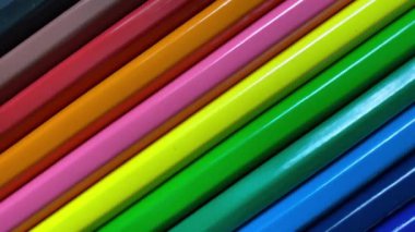 Çapraz bir çizgide dizilmiş renkli kalemlerden oluşan canlı, yakın plan bir video. Video, mavi ve yeşilden sarı, turuncu ve turuncu renklere doğru parlak bir spektrum sergileyerek yavaş ve pürüzsüz bir şekilde işliyor.