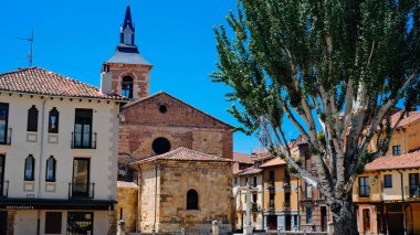 Leon, İspanya 'da güneşli bir kasaba meydanı. İçinde tarihi bir taş kilise ve karanlık bir çan kulesi var. Meydanın etrafı terracottalı geleneksel binalarla çevrili.