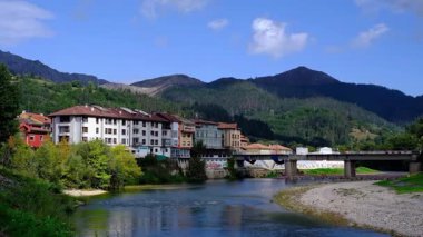 İspanya 'nın Asturias kentindeki Arriondas kasabasının içinden sakin bir nehrin aktığı pitoresk bir videosu. Kamera, geleneksel mimari astarlı bir dizi büyüleyici binayı yakalar.