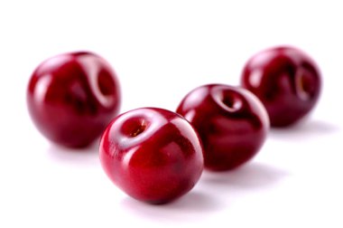 Beyaz arka plan üzerinde dört kiraz meyveleri yakın çekim  