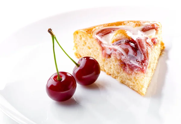 樱桃浆果与小枝和一块奶油水果馅饼在白色的盘子特写镜头 — 图库照片