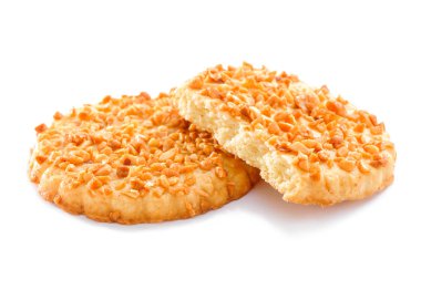 Beyaz arka plan üzerinde izole ezilmiş fındık yakın çekim ile tepesinde iki tereyağlı kurabiye 