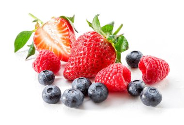 taze çilek böğürtlen, ahududu ve çilek yakın çekim su damlaları beyaz zemin üzerine serpilir 