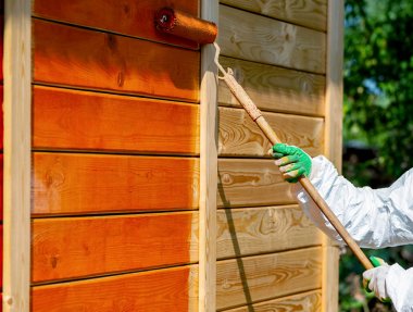 Boya ahşap duvar turuncu renkli rulo fırça ile çalışma giysileri açık çekim ressam tarafından  