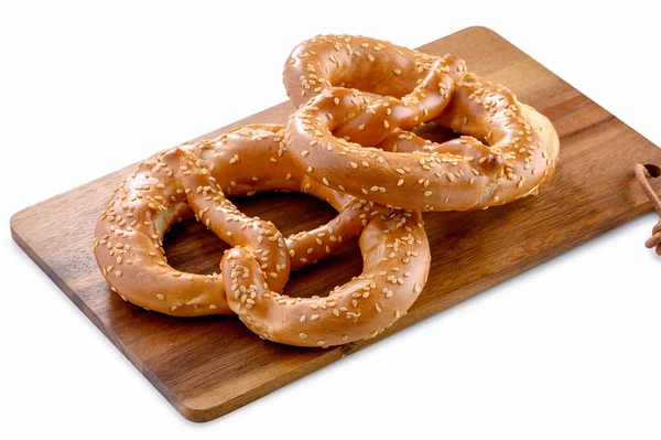 Twee Pretzels Met Sesamzaden Close Houten Bord Geïsoleerd Witte Achtergrond — Stockfoto