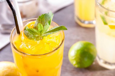 narenciye yanında masada buz, nane yaprağı ve plastik saman ile limonata yakın çekim cam