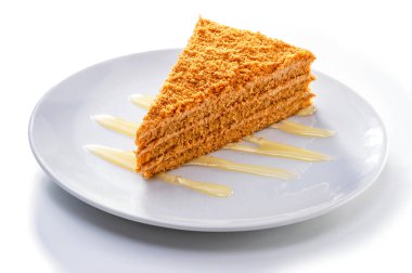 beyaz arka plan karşı plaka üzerinde sıvı bal dekorasyon ile kremsi bal kek parçası  