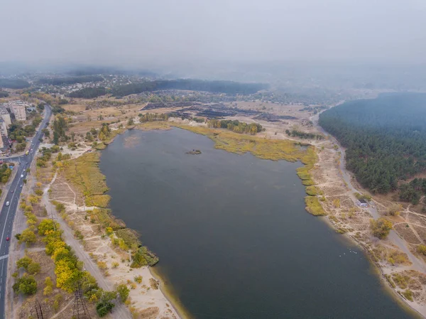 Fog covers the forest and small lake