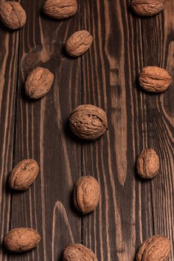 Cevizler koyu kahverengi ahşap kalaslardan yapılmış bir masanın üstünde yatar..