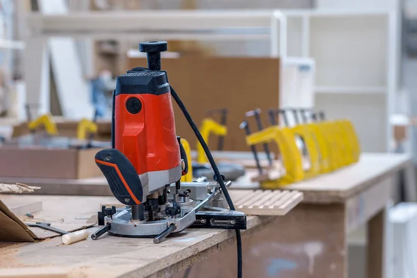 A working tool in a wooden furniture factory, close-up against a blurred background. High quality photo