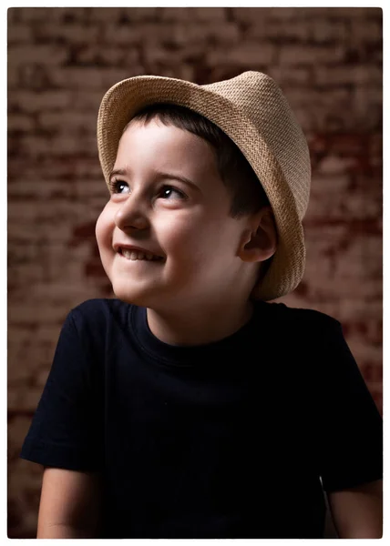 Portret van een lachende jongen voor een bakstenen muur — Stockfoto