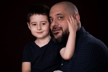 Siyah arka planda sakallı baba oğul portresi