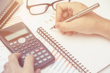 İş adamı Ofiste çalışan masanın üzerinde yatırım grafiği analiz hesap makinesi kullanma. iş kavramı.