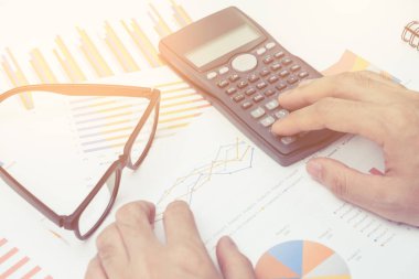 İş adamı Ofiste çalışan masanın üzerinde yatırım grafiği analiz hesap makinesi kullanma. iş kavramı.