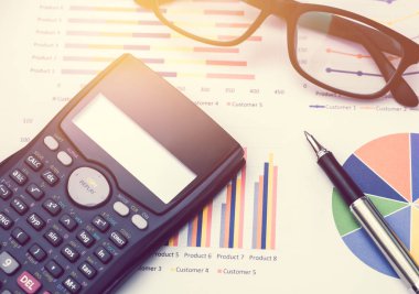 Masa ofisi üzerindeki grafik ve grafikten veri analizi için hesap makinesi ve kalem. iş kavramı