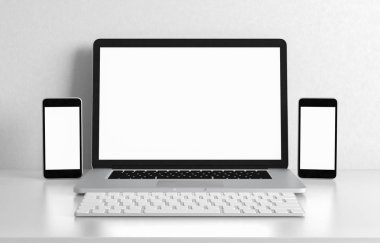 Bilgisayar dizüstü bilgisayarı ve telefon boş ekranı beyaz ofis masasında, çalışma alanı tasarım çizimi 3D görüntüleme