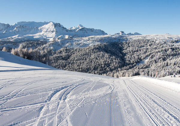 Fresh groomed ski piste with amazing winter landscape in the Alps, Dolomites, Morning view. Alta Badia, Sella Ronda. Italy. Famous ski resort.